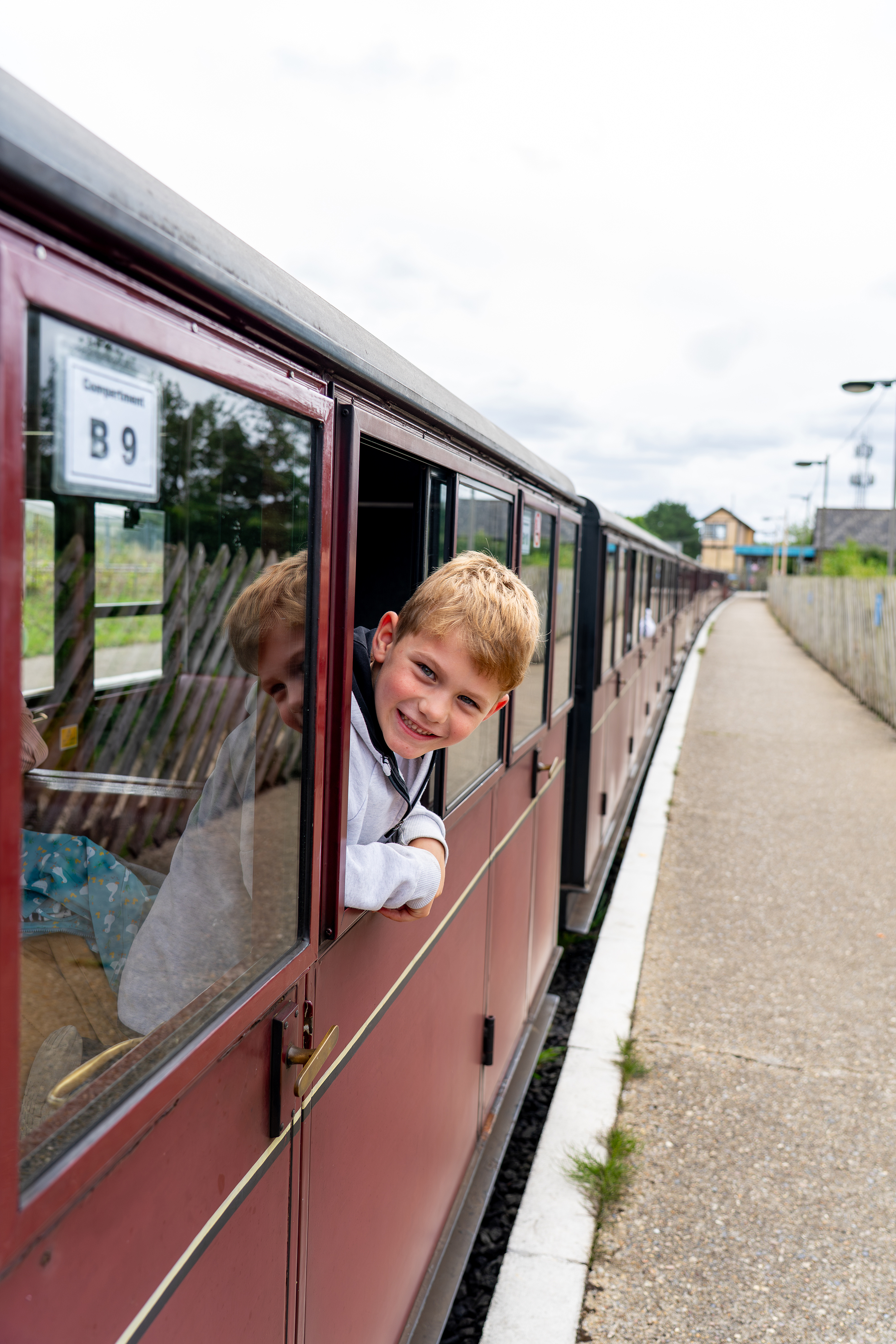 Boy poking his head out of the carriage at Wroxham Station