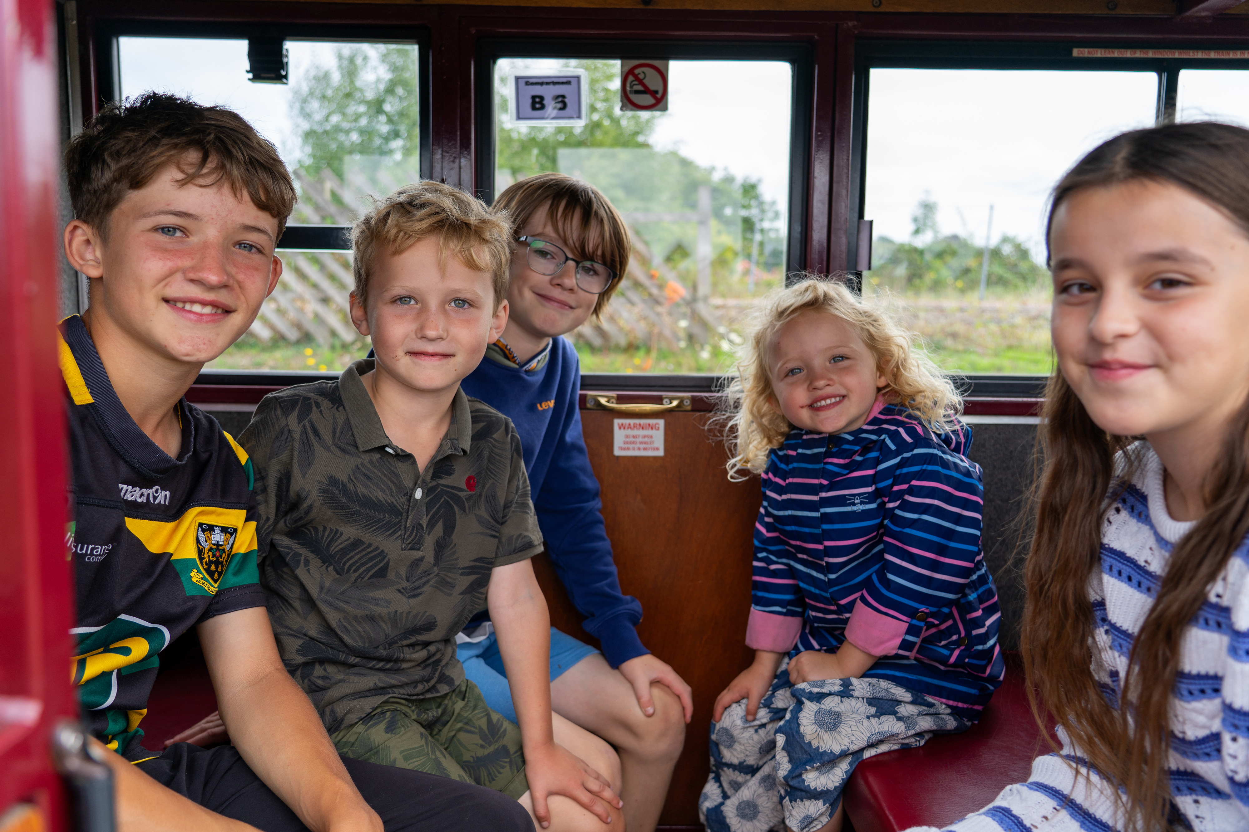 A group of children in a carriage ready to depart Wroxham Station